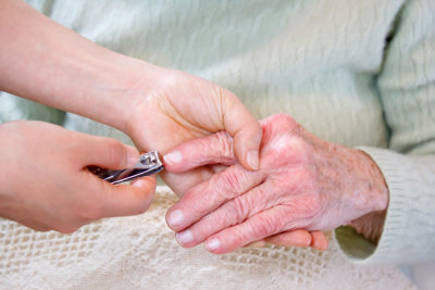 Helping senior woman cutting her fingernails